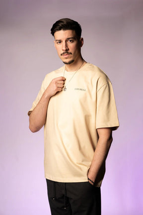 Beiges T-Shirt aus 100% Baumwolle mit schwarzem 'LOURELL' Logo-Print auf der Brust – Unisex Basic Shirt.