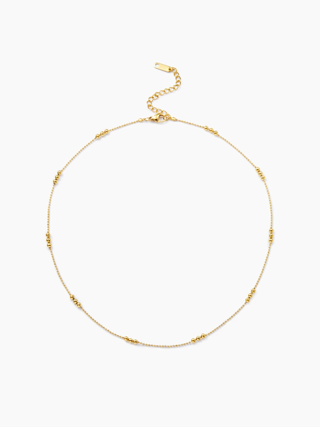 Zarte goldene Halskette im Kugel-Design, bei der sich feine Kettenglieder mit Gruppen von drei größeren, glänzenden Goldkugeln abwechseln.