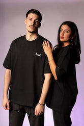 Schwarzes Oversize T-Shirt mit weißem Logo auf der Brust und Lourell-Schriftzug am Ärmel.