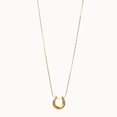 Feine Halskette in Gold, an der ein glänzender, gebogener Loop-Anhänger gleitet.