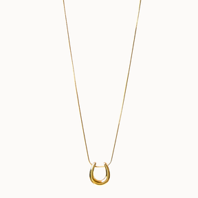 Feine Halskette in Gold, an der ein glänzender, gebogener Loop-Anhänger gleitet.