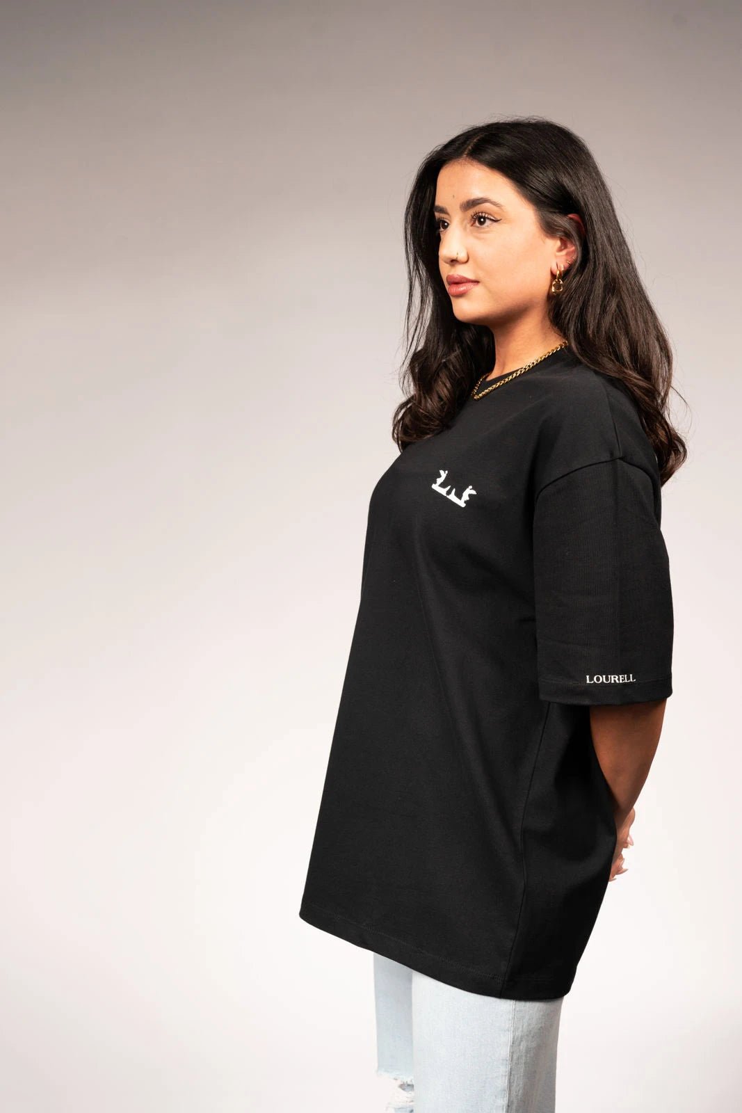 Schwarzes Oversize T-Shirt mit weißem Logo auf der Brust und Lourell-Schriftzug am Ärmel.
