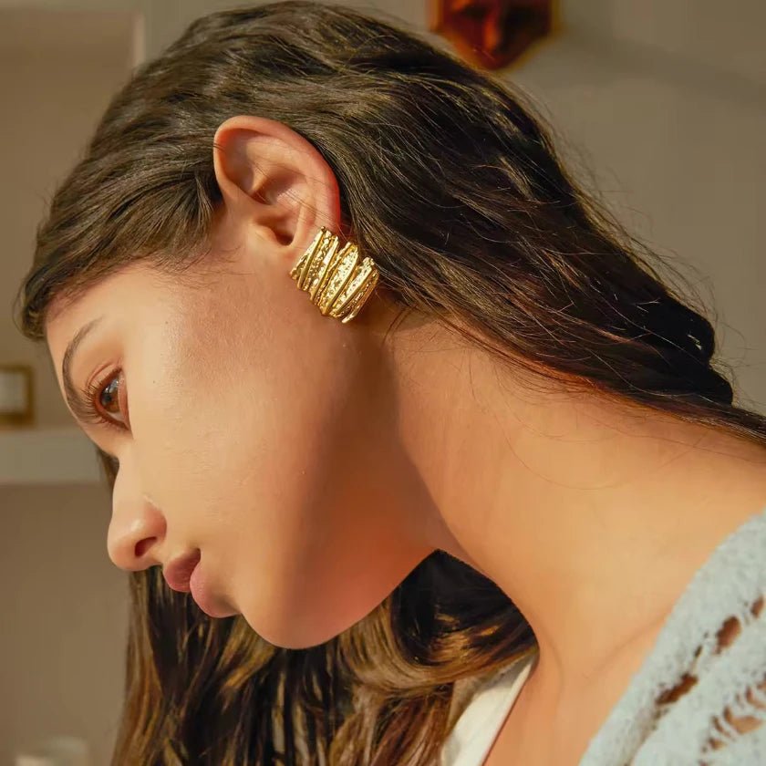 Goldene Vintage-Ohrstecker mit strukturierter, wellenförmiger Oberfläche im Antik-Look.