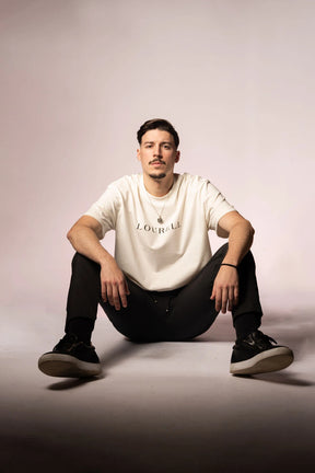 Weißes Oversize T-Shirt aus 100% Baumwolle mit großem, zentriertem 'LOURELL' Schriftzug in Schwarz auf der Brust.