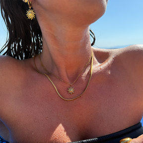 Feiner Sonnenanhänger kombiniert mit glatter goldener Snake-Chain im Layering-Look.