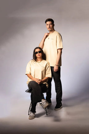 Beiges T-Shirt aus 100% Baumwolle mit schwarzem 'LOURELL' Logo-Print auf der Brust – Unisex Basic Shirt.