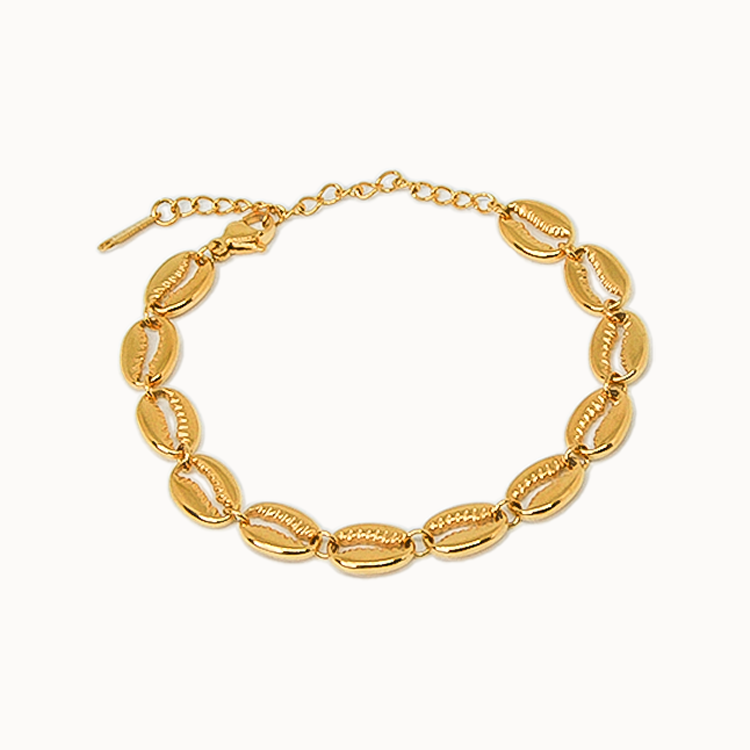 Armband aus aneinandergereihten, gold-glänzenden Kaurimuscheln mit verstellbarem Verschlusskettchen.
