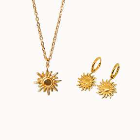 Schmuck-Duo in Gold: Eine feine Gliederkette mit großem Sonnen-Motiv und dazu passende kleine Creolen mit hängenden Sonnen.