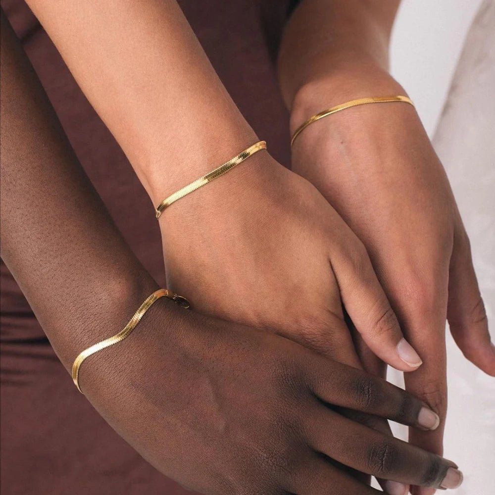 Flaches Herringbone-Armband in Gold – glänzende Fischgräten-Kette für das Handgelenk.