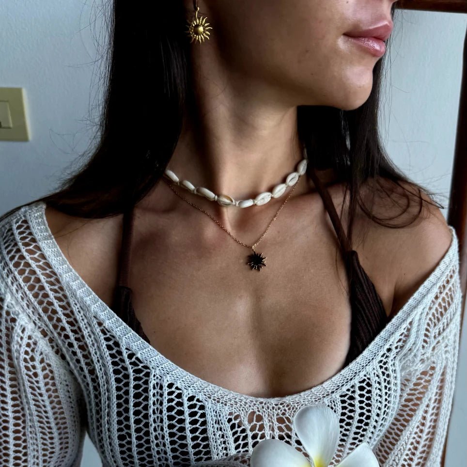 Schmuck-Duo in Gold: Eine feine Gliederkette mit großem Sonnen-Motiv und dazu passende kleine Creolen mit hängenden Sonnen.
