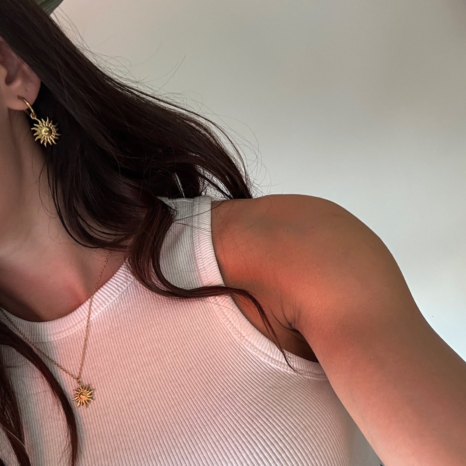 Schmuck-Duo in Gold: Eine feine Gliederkette mit großem Sonnen-Motiv und dazu passende kleine Creolen mit hängenden Sonnen.