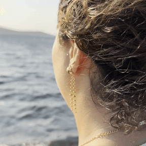 Goldene Statement-Ohrhänger mit großer Kugel und langen, feinen Kugelketten.