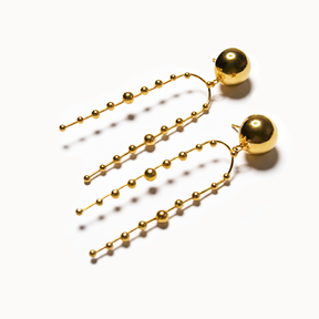 Goldene Statement-Ohrhänger mit großer Kugel und langen, feinen Kugelketten.